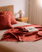 Orange Kuscheldecke auf dem Bett mit passenden Kissen